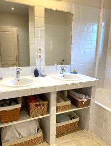 łazienka z 2 umywalkami i dużym lustrem w obiekcie Chambre avec vue w mieście Saint-Quentin-la-Poterie