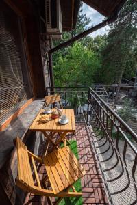 y balcón con mesa y sillas de madera. en Къща за гости Димови, en Sozopol