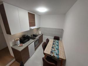 eine kleine Küche mit einem Holztisch und Stühlen in der Unterkunft Apartman Muzika Jagodina in Jagodina
