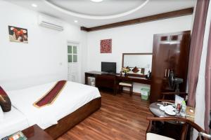 1 dormitorio con cama y escritorio con espejo en Khách sạn Rococo, en Hanói