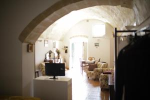 un soggiorno con arco, TV e sedie di Tutte le Albe nei Sassi a Matera