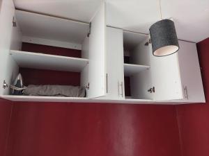 a room with white cabinets and a red wall at Stylish Studio on Ngong Road in Nairobi +4 photos