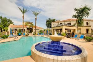 a pool with a fountain in front of a house at Tranquil Scottsdale Condo with Community Pool! in Scottsdale