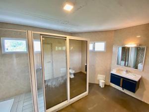 La salle de bains est pourvue d'une douche en verre et d'un lavabo. dans l'établissement Fini Hotel Bobende, à Limbe