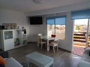 sala de estar con mesa y comedor en Cassinello Roquetas en Roquetas de Mar