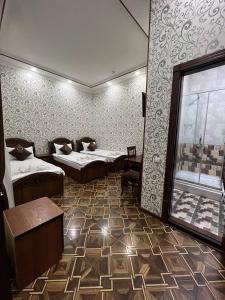 Zimmer mit 2 Betten und einem Fenster in der Unterkunft FIRDAVS HOTEL in Navoiy