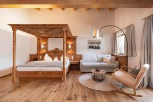 1 dormitorio con cama con dosel y sofá en Hotel Stubaierhof en Neustift im Stubaital