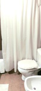 a bathroom with a toilet and a white shower curtain at Apartamento en piso 22 , con increíble vista! Ramón Bautista Mestre 1850, ANTIGUA CERVECERÍA CÓRDOBA in Córdoba