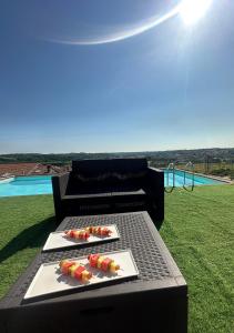 two plates of food on a table with a pool at Villa Bordone in Villafranca dʼAsti