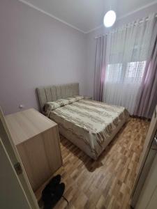 1 dormitorio con 1 cama, vestidor y ventana en Family Oasis en Vlorë