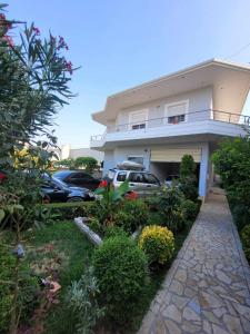 a house with cars parked in a parking lot at Family Oasis in Vlorë