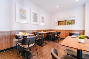 a restaurant with wooden floors and tables and chairs at Timhotel Tour Eiffel in Paris