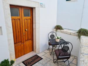 uma mesa e duas cadeiras em frente a uma porta em La Dimora nel Borgo em Locorotondo