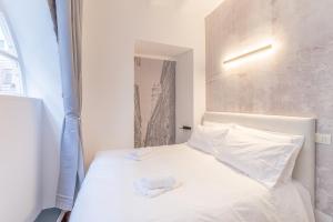 a bedroom with a white bed with two towels on it at [Genova Centro] Colonna-Cattedrale di San Lorenzo in Genova