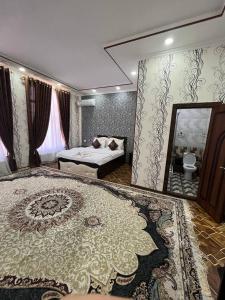 a bedroom with a bed and a mirror and a rug at FIRDAVS HOTEL in Navoi