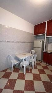 a kitchen with a table and chairs and a refrigerator at Pearl in the Middle Atlas - ground floor in Azrou