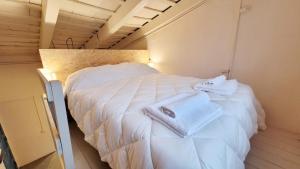 a large white bed in a room with towels on it at Interra Apart 2 in Salta