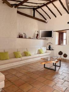 a living room with a white couch and a tv at Casa Real Barichara in Barichara