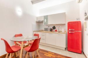 a kitchen with a red refrigerator and a table and chairs at [Genova Centro] Colonna-Cattedrale di San Lorenzo in Genova