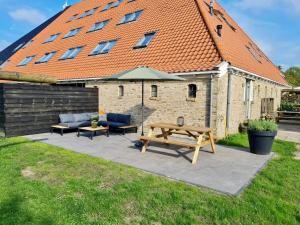 a patio with a picnic table and an umbrella at Verblijf bij Bynt in Sneek