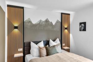 a bedroom with a bed with pillows and a mountain mural at STANMA Luchspartment ruhig und zentral mit großem Balkon und Parkplatz in Braunlage