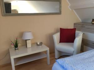 a bedroom with a chair and a table with a red pillow at Ferienwohnung Lini in Schwerin