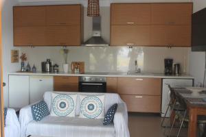 a living room with a white couch in a kitchen at A Crystal Clear House in Pyrgos, Heraklion Crete in Pírgos