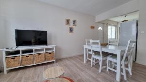 een woonkamer met een eettafel en een tv bij Appartement RDC à 2 pas de la Plage et des commerces de BERCK PLAGE in Berck-sur-Mer