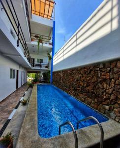 a swimming pool in a house with a stone wall at blue BOCANA in Santa Cruz Huatulco