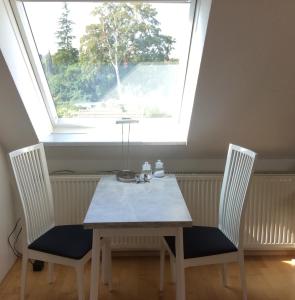 una mesa y dos sillas frente a una ventana en Ferienwohnung Lini, en Schwerin