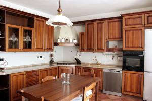 cocina con armarios de madera y mesa de madera en Room in Guest room - La Culla Tra I Vigneti - Stanza, en Grazzano Badoglio