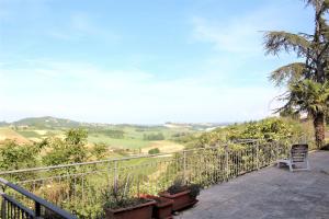 una silla sentada en un balcón con vistas a las colinas en Room in Guest room - La Culla Tra I Vigneti - Stanza, en Grazzano Badoglio