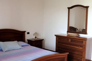 1 dormitorio con cama, tocador y espejo en Room in Guest room - La Culla Tra I Vigneti - Stanza, en Grazzano Badoglio