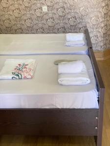 Una cama con dos toallas encima. en Hotel Mariana en Kutaisi