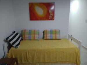 uma cama com duas almofadas e um quadro na parede em NEW YORK EN EDIFICIO MAFALFA COCHERA y Asador INCLUIDA em Río Cuarto