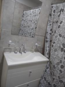 uma casa de banho com um lavatório e uma cortina de chuveiro em NEW YORK EN EDIFICIO MAFALFA COCHERA y Asador INCLUIDA em Río Cuarto