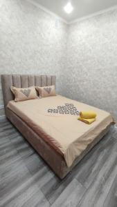 Un dormitorio con una cama con un objeto amarillo. en Люкс апартаменты в ЖК Shanyrak, en Pavlodar