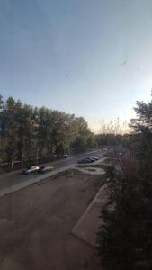 un estacionamiento con autos estacionados al lado de una carretera en Люкс апартаменты в ЖК Shanyrak, en Pavlodar