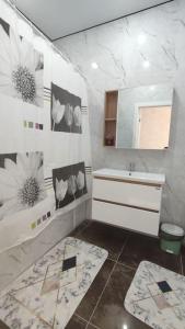 ein Bad mit einem Waschbecken und einem Spiegel in der Unterkunft Люкс апартаменты в ЖК Shanyrak in Pawlodar