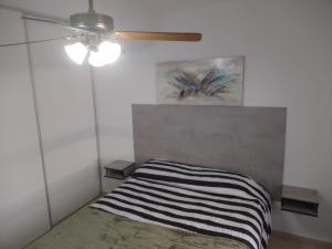 um quarto com uma cama e uma ventoinha de tecto em NEW YORK EN EDIFICIO MAFALFA COCHERA y Asador INCLUIDA em Río Cuarto