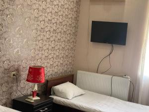 a bedroom with two beds and a tv on the wall at Hotel Mariana in Kutaisi