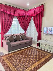 a living room with a couch and red curtains at Sofea Homestay Ipoh in Ipoh