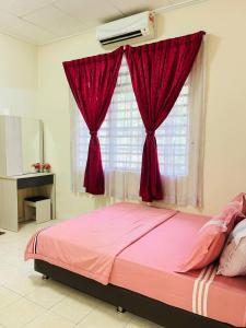 a bedroom with a pink bed with a window at Sofea Homestay Ipoh in Ipoh