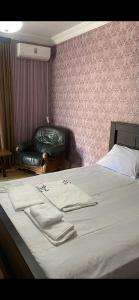 a bedroom with a bed with two towels on it at Hotel Mariana in Kutaisi