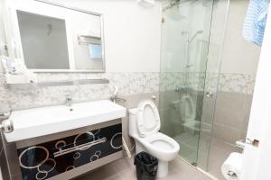 uma casa de banho com um lavatório, um WC e um chuveiro em Khách sạn Rococo em Hanói