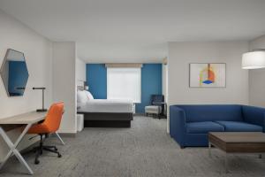 a living room with a blue couch and a bed at Holiday Inn Express & Suites Superior, an IHG Hotel in Superior