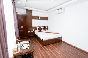 Habitación de hotel con cama y mesa en Khách sạn Rococo, en Hanói