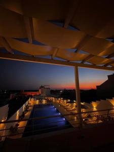 een balkon met tafels en stoelen in de nacht bij Zahra Superior Suite with private pool in Sannicola