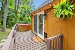 a house with a wooden deck with a porch at Quaint Loft Cabin w Hot Tub, FirePit, Deck & Grill in Hedgesville