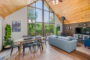 a living room with a couch and a table and chairs at Quaint Loft Cabin w Hot Tub, FirePit, Deck & Grill in Hedgesville